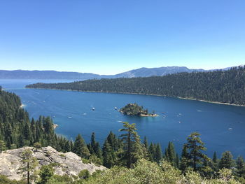 Scenic view of lake and mountains against clear blue sky