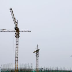Low angle view of crane against clear sky