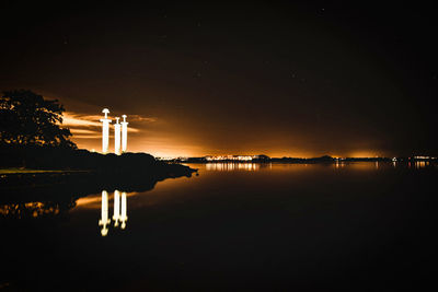 Scenic view of lake against sky at night