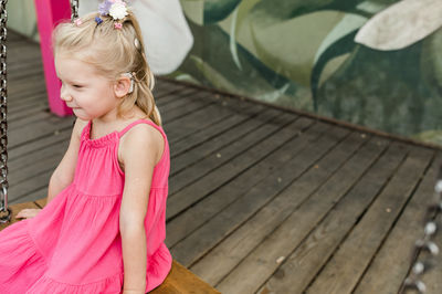 Portrait of young woman sitting on boardwalk