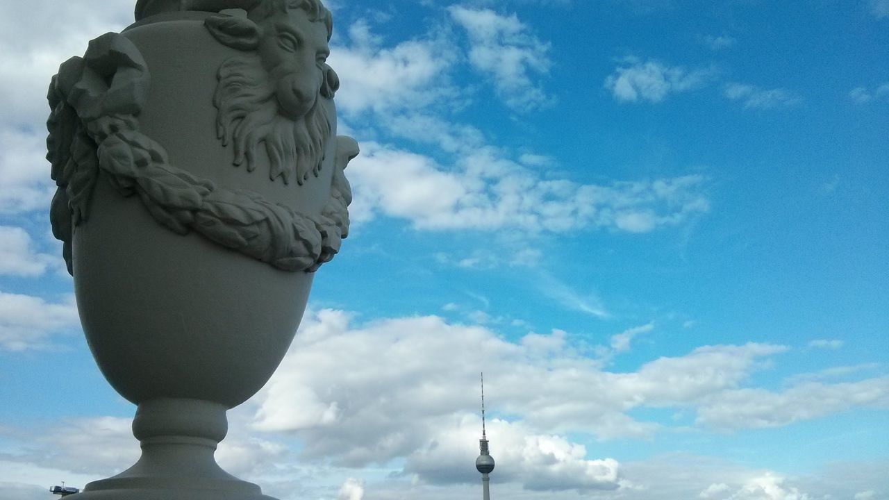 cloud - sky, sky, statue, art, sculpture, human representation, travel destinations, art and craft, low angle view, tourism, blue, famous place, day, creativity, outdoors, cloudy, human face, cloudscape, culture, international landmark, cumulus cloud, monument, no people