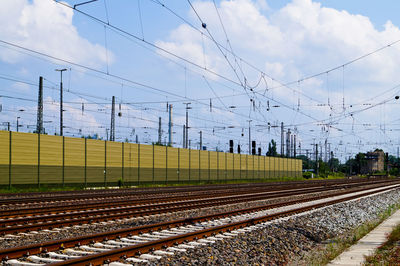 Railroad tracks and electricity pylon against sky