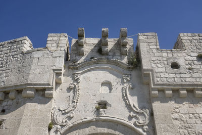 Low angle view of old building against clear blue sky