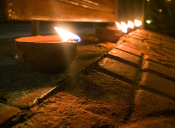 Close-up of lit candles on retaining wall