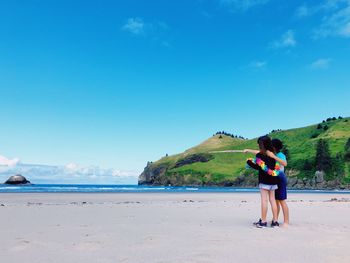 Woman on beach against blue sky