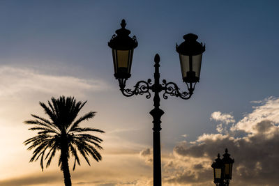 Low angle view of silhouette street light against sky