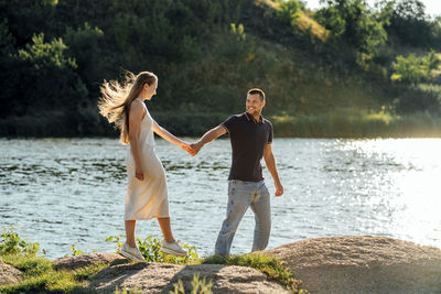 Declarations of love, candid couple in love holding hands on nature background.