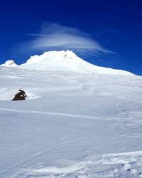 Scenic view of snowcapped mountain against blue sky