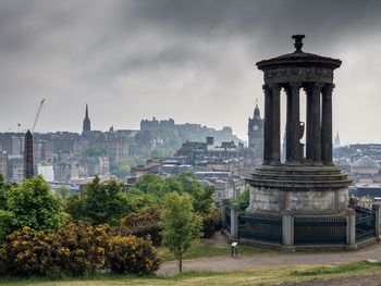 View of tower and buildings against cloudy sky