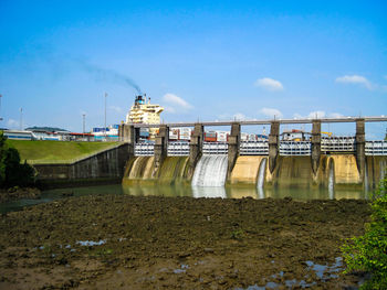 View of dam by river against sky