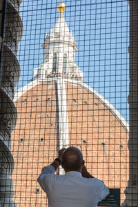 Rear view of man on building against sky