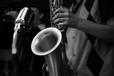 Midsection of man playing saxophone during concert