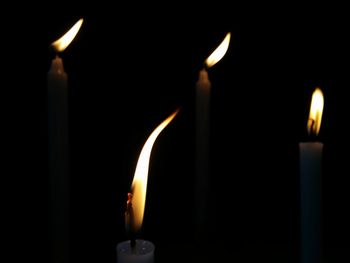 Close-up of lit candle in darkroom