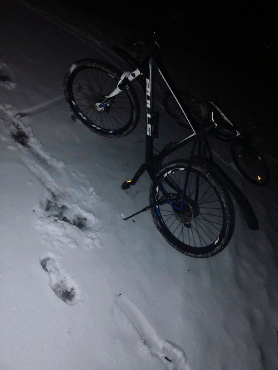 BICYCLE PARKED ON SNOW COVERED FIELD AGAINST SKY