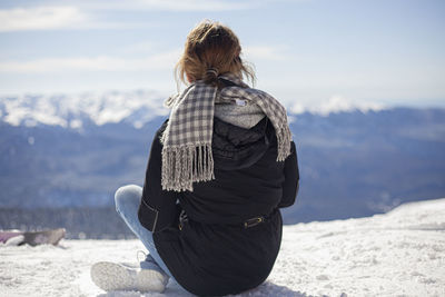 Rear view of woman looking at mountain during winter