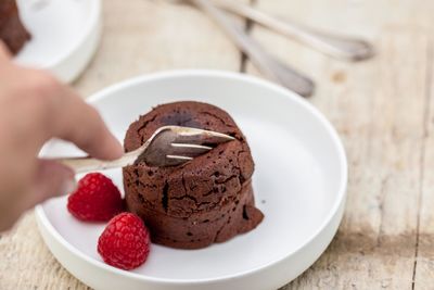 Close-up of hand holding ice cream in plate