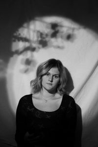 Young woman standing against wall