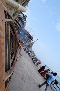 People on boat in city against sky