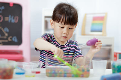 Cute girl playing with toy at home