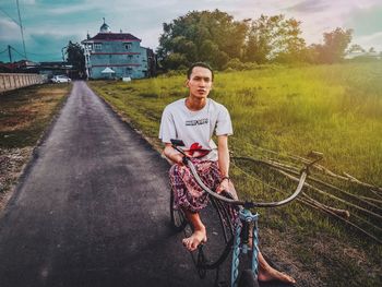 Portrait of man standing on field against sky