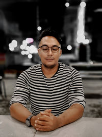 Portrait of young man sitting on table