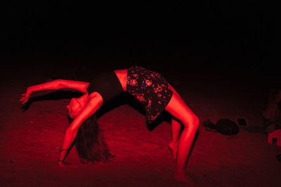 Side view of woman on beach at night