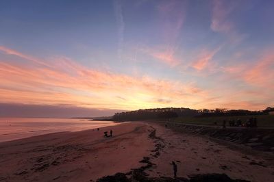 Scenic view of beach against sky during sunset