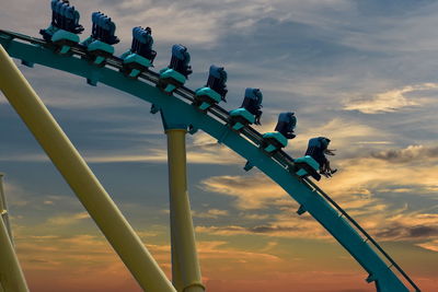 Low angle view of ferris wheel against sky during sunset