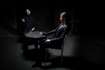 Side view of couple sitting on chair