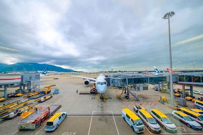 Airplane on airport runway against sky