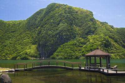 Built structure by lake against sky