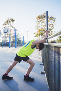 Rear view of woman with arms raised against sky