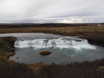 Scenic view of waterfall against sky