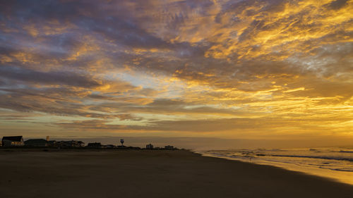 Scenic view of beach against dramatic sky