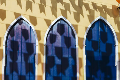 Shadow of flags on blue doors