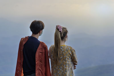 Rear view of group people standing against sky