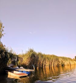 Boats moored in lake against sky