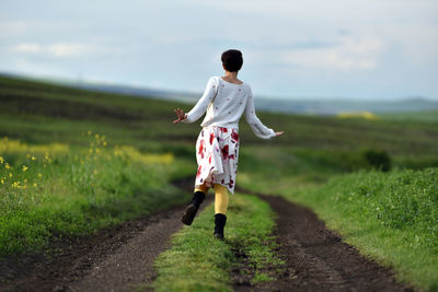 Rear view of man walking on road