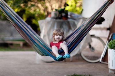 Portrait of cute baby girl sitting on hammock