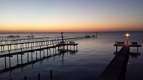 Pier on sea against sky during sunset