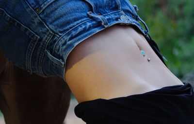 Midsection of woman with pierced belly button