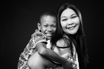 Portrait of mother and son against black background