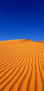 Scenic view of desert against clear blue sky