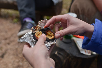 Close-up of hands eating wrapped food