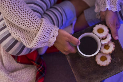 High angle view of hand holding coffee cup