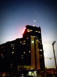 Low angle view of illuminated building against sky at night