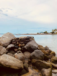 Rocks in sea against sky