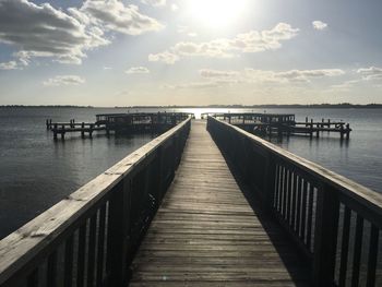 Pier on sea against sky during sunny day