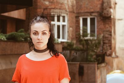 Portrait of woman standing against building