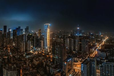 Illuminated cityscape against sky at night